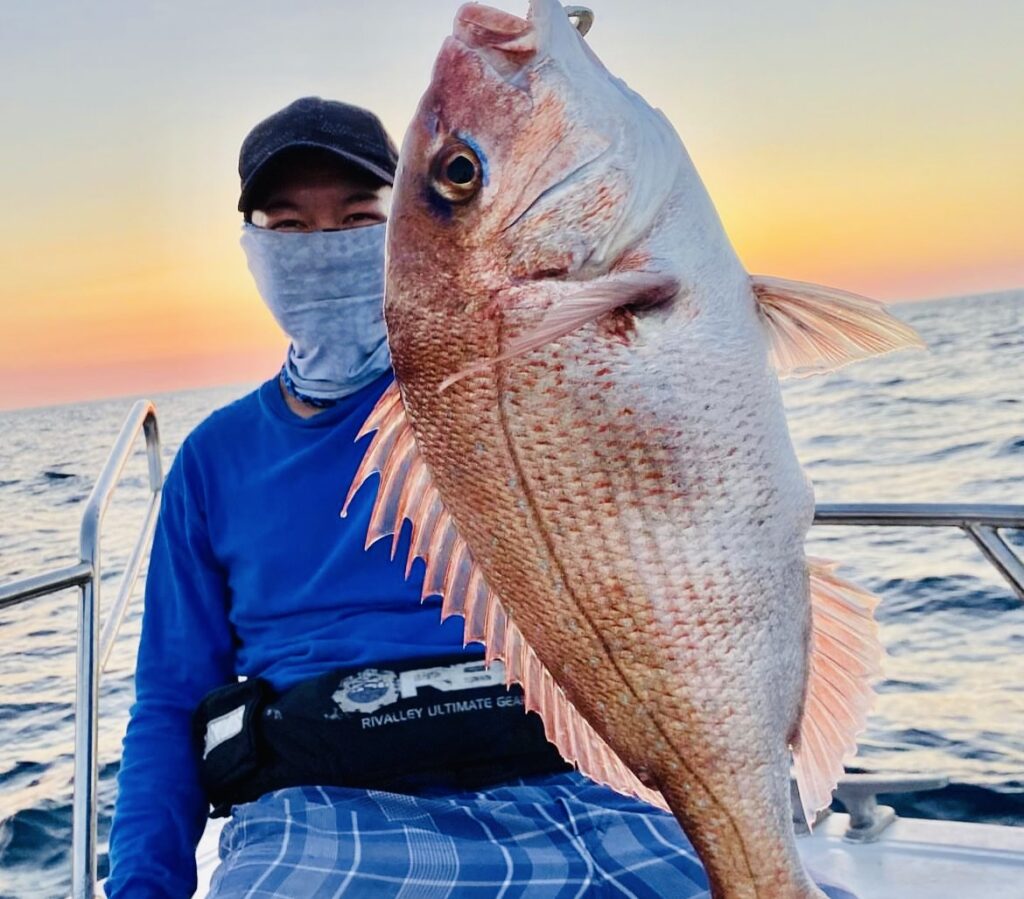 Captain Shigeki Ishida holding a large red seabream (madai) caught aboard FOLK IN ON